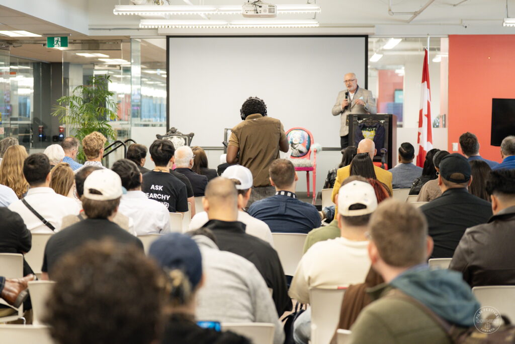 An audience fills the room as a speaker addresses the AI & Film Forum from the stage.