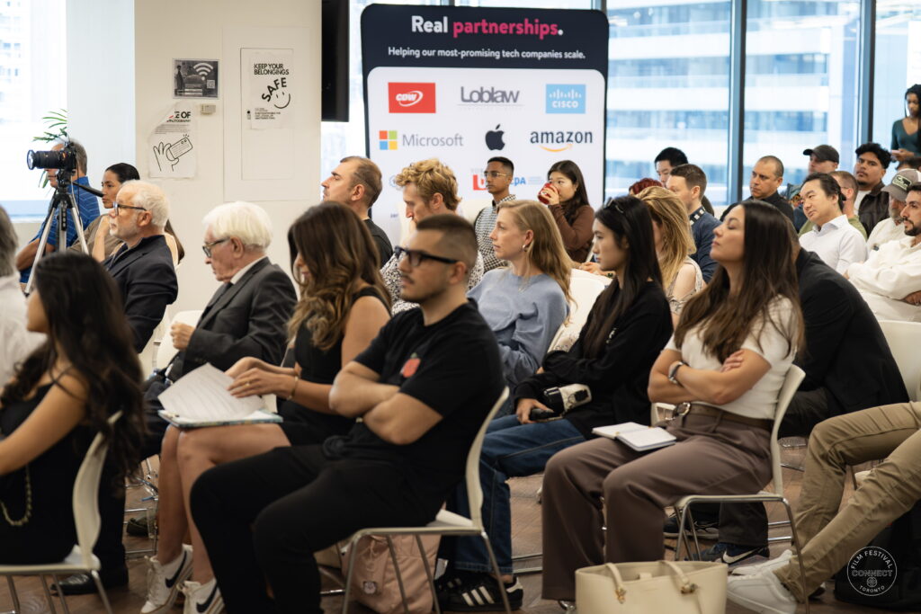 Attendees listen to the AI & Film Forum, with a venue partner banner behind them.