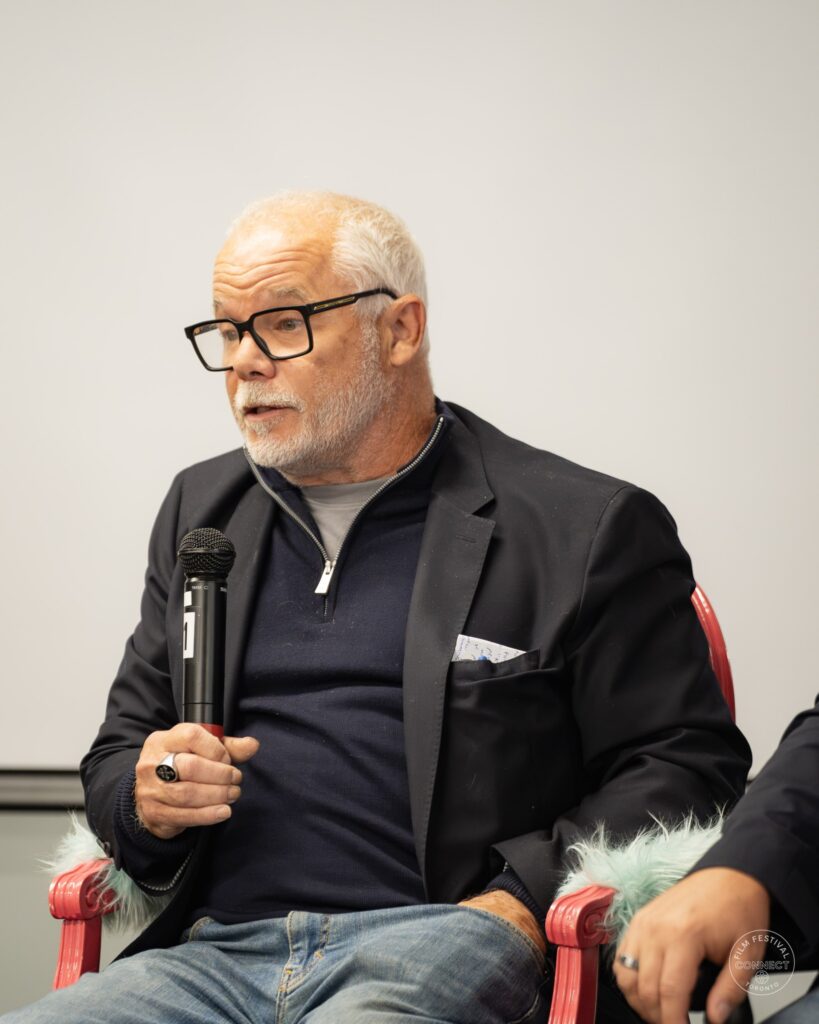 A panel participant with glasses and a white beard speaks into a microphone. AI & Film Forum, Panel 3, September 14, 2026.