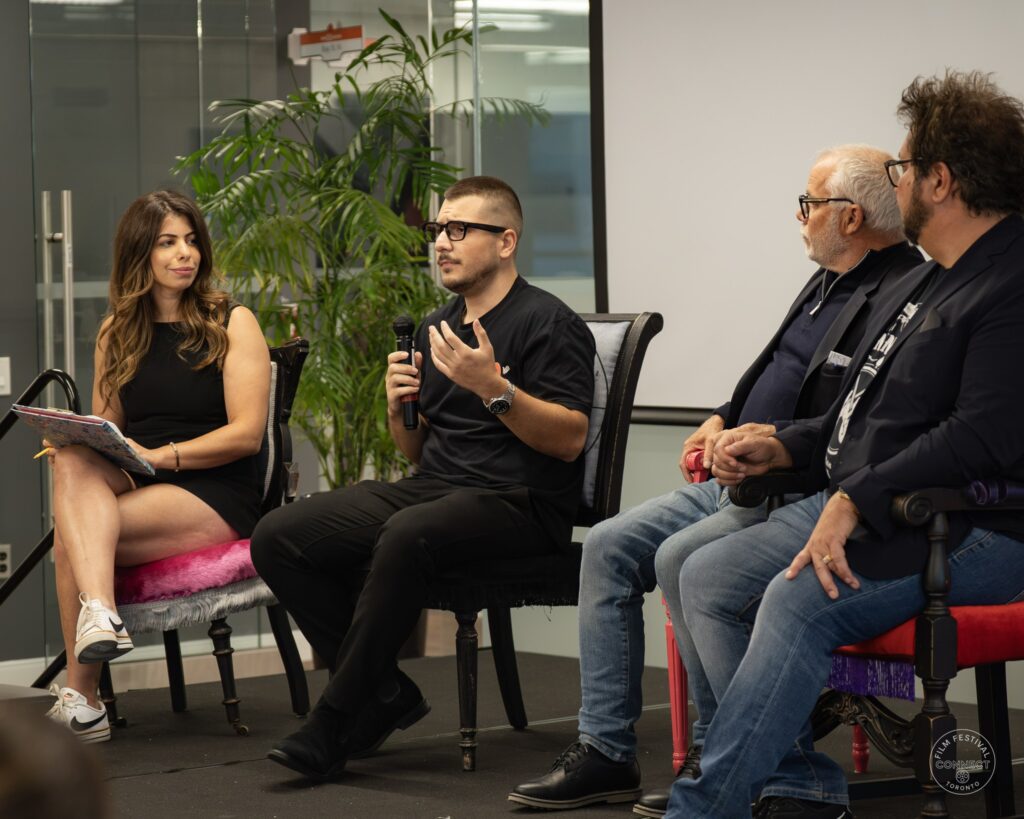 One participant speaks and gestures while the other three turn toward the conversation. AI & Film Forum, Panel 3, September 14, 2026.