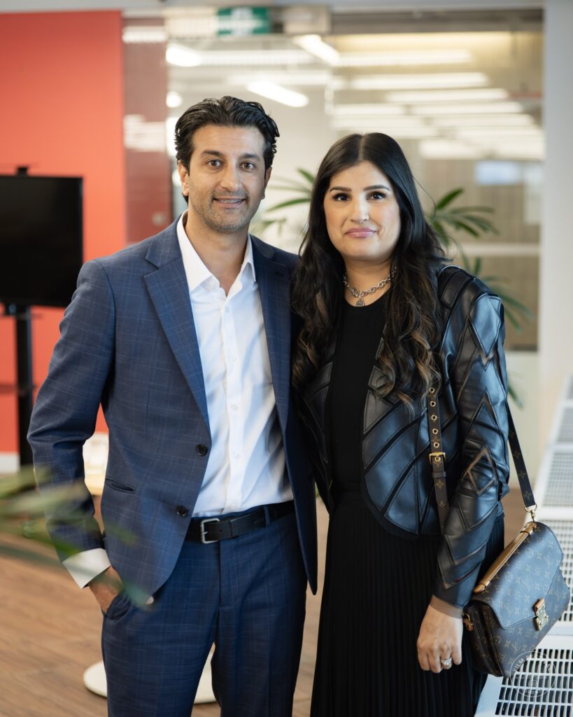 A man in a blue suit and a woman in a black jacket pose together at the AI & Film Forum.